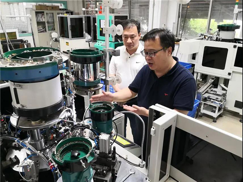 華圣達(dá)技術(shù)設(shè)備中心研發(fā)人員(右)在介紹自主研發(fā)的智能生產(chǎn)拉鏈機(jī)械設(shè)備 華圣達(dá)技術(shù)設(shè)備中心研發(fā)人員(右)在介紹自主研發(fā)的智能生產(chǎn)拉鏈機(jī)械設(shè)備